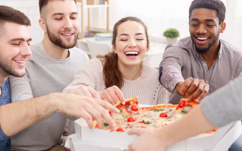 friends-taking-slices-of-hot-pizza-from-cardboard-XD65K9Y-min.jpg